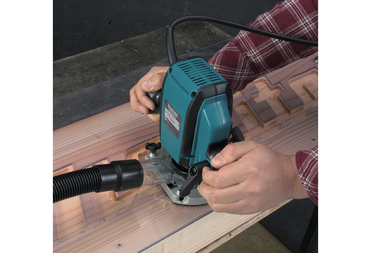 Απεικονίζεται το γράψιμο γραμμάτων σε ξύλινη επιφάνεια με τη χρήση του ρούτερ.